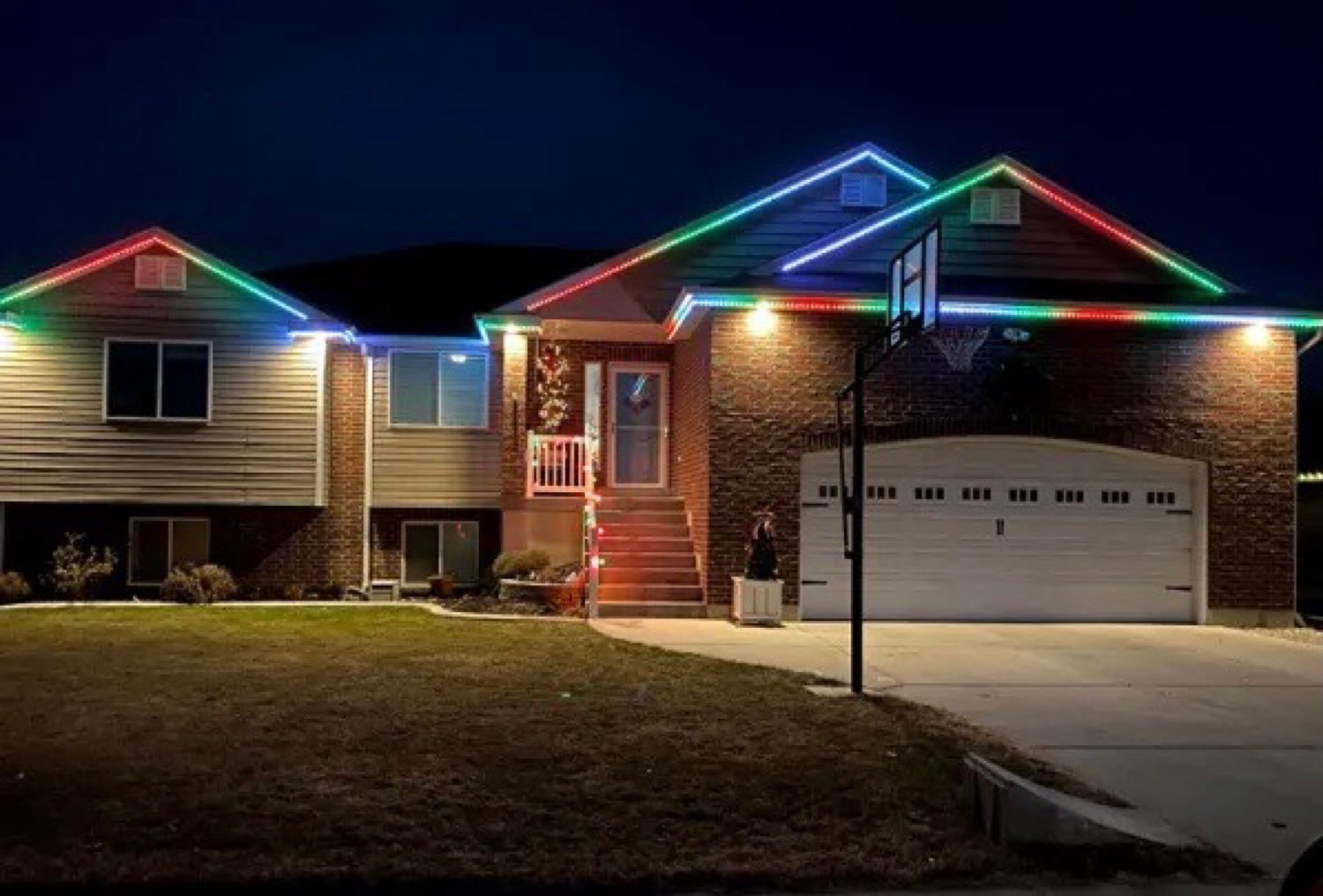 Brick home with color-changing permanent LEDs along the fascia and peaks